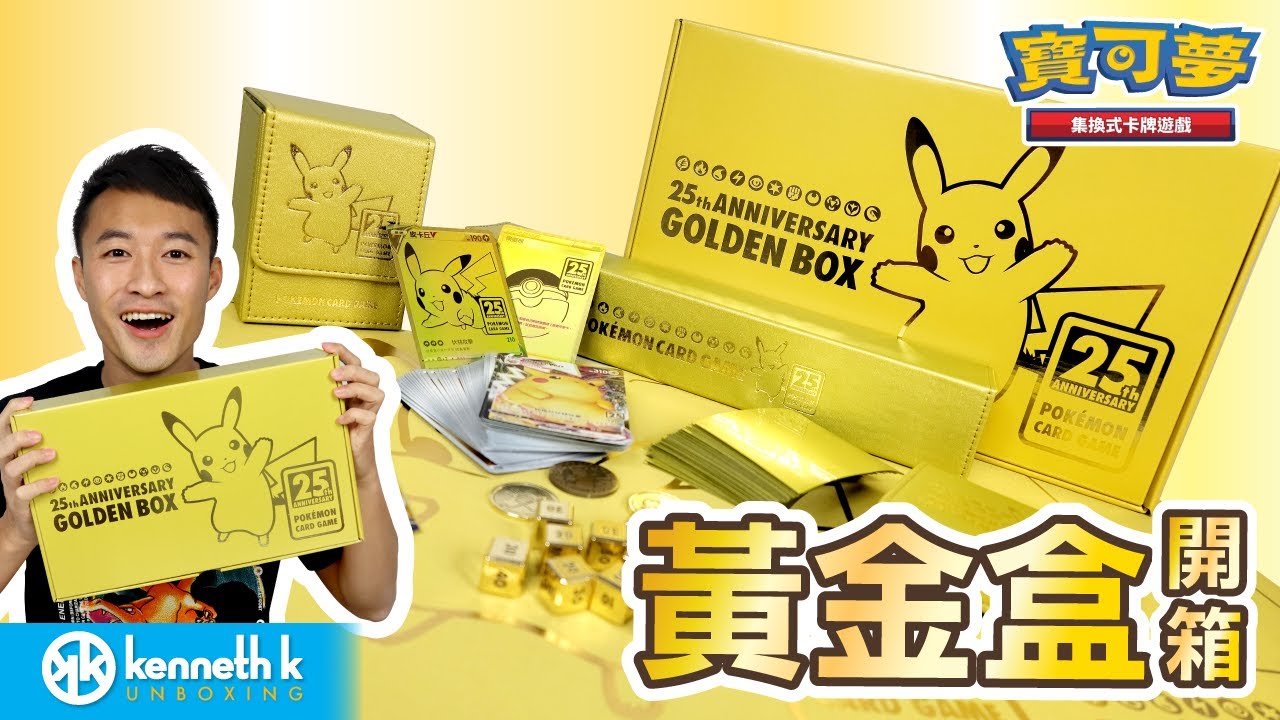 玩家在木質或普通桌面上開箱「25週年黃金紀念盒」的實拍照,畫面中包含已打開的皮製卡盒、金色骰子、硬幣以及散落的卡片,背景為真實的居家或卡牌店環境,非官方宣傳圖。(圖片出處:https://www.youtube.com/watch?v=RLj91WfrZeM)